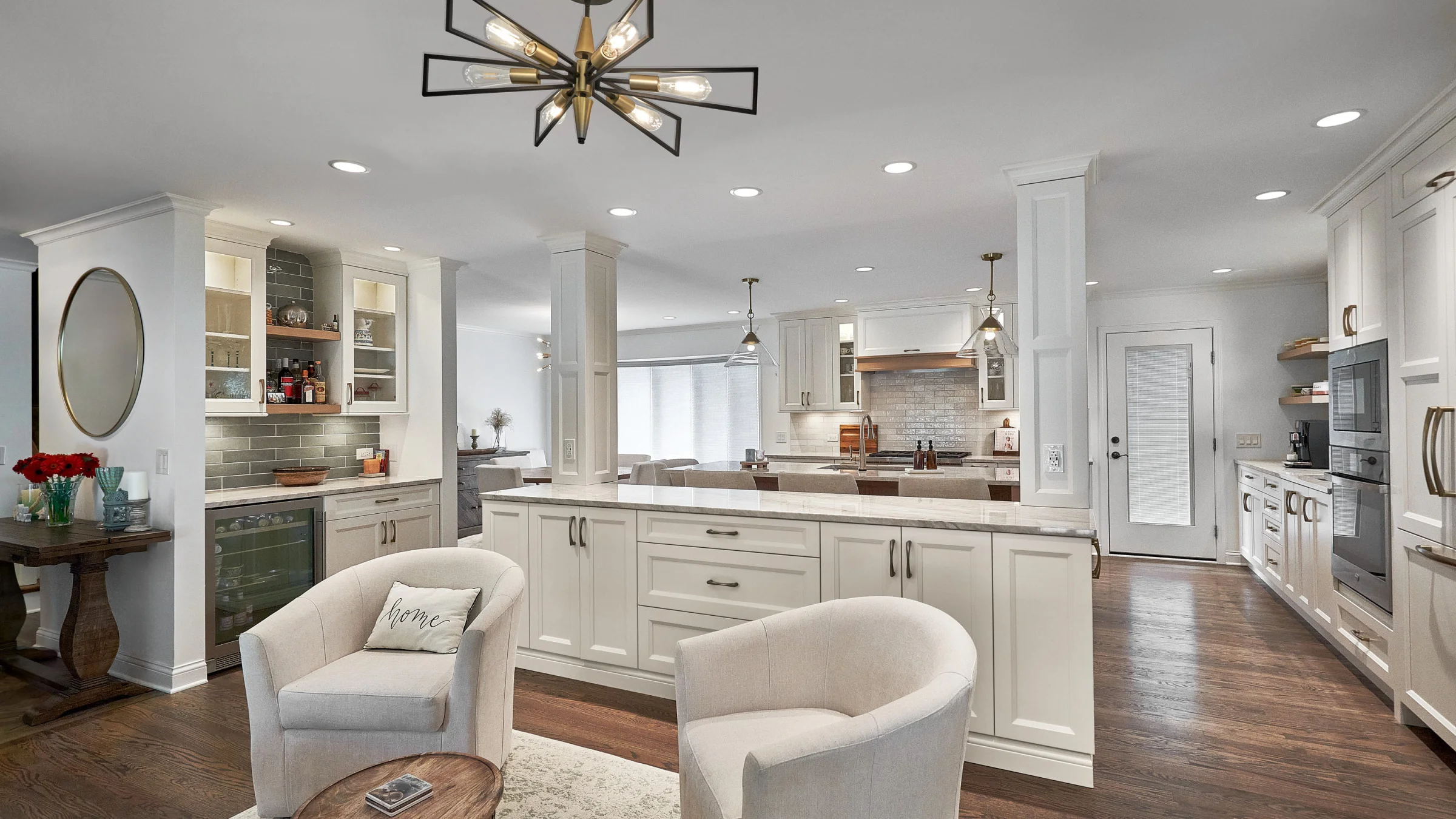 Arlington Heights kitchen remodel with white cabinets, hardwood floors, island seating, & modern light fixture.