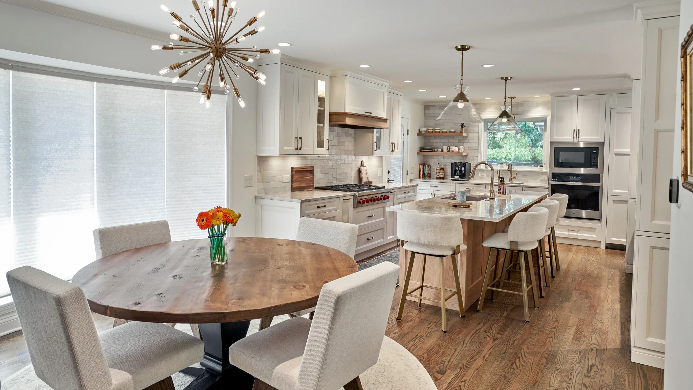 Bright, open kitchen remodel with white cabinets, wood island, hardwood floors, and modern lighting in Arlington Heights, IL.