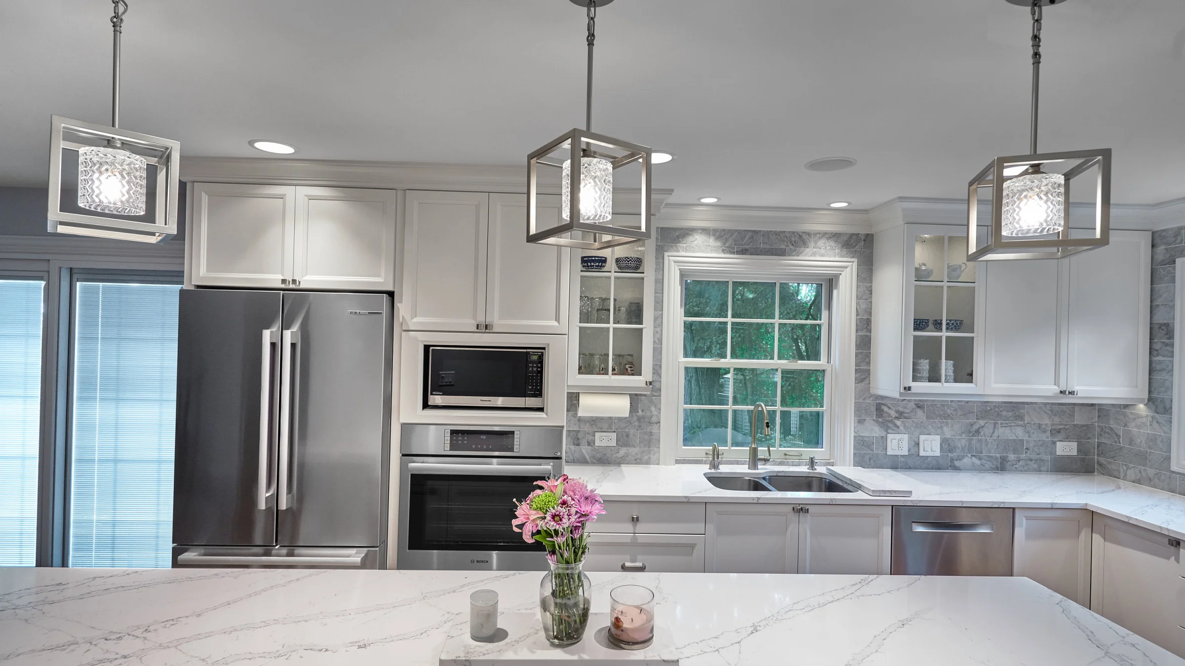 Arlington Heights kitchen remodel featuring white cabinets, marble backsplash, quartz countertops, and modern pendant lightin