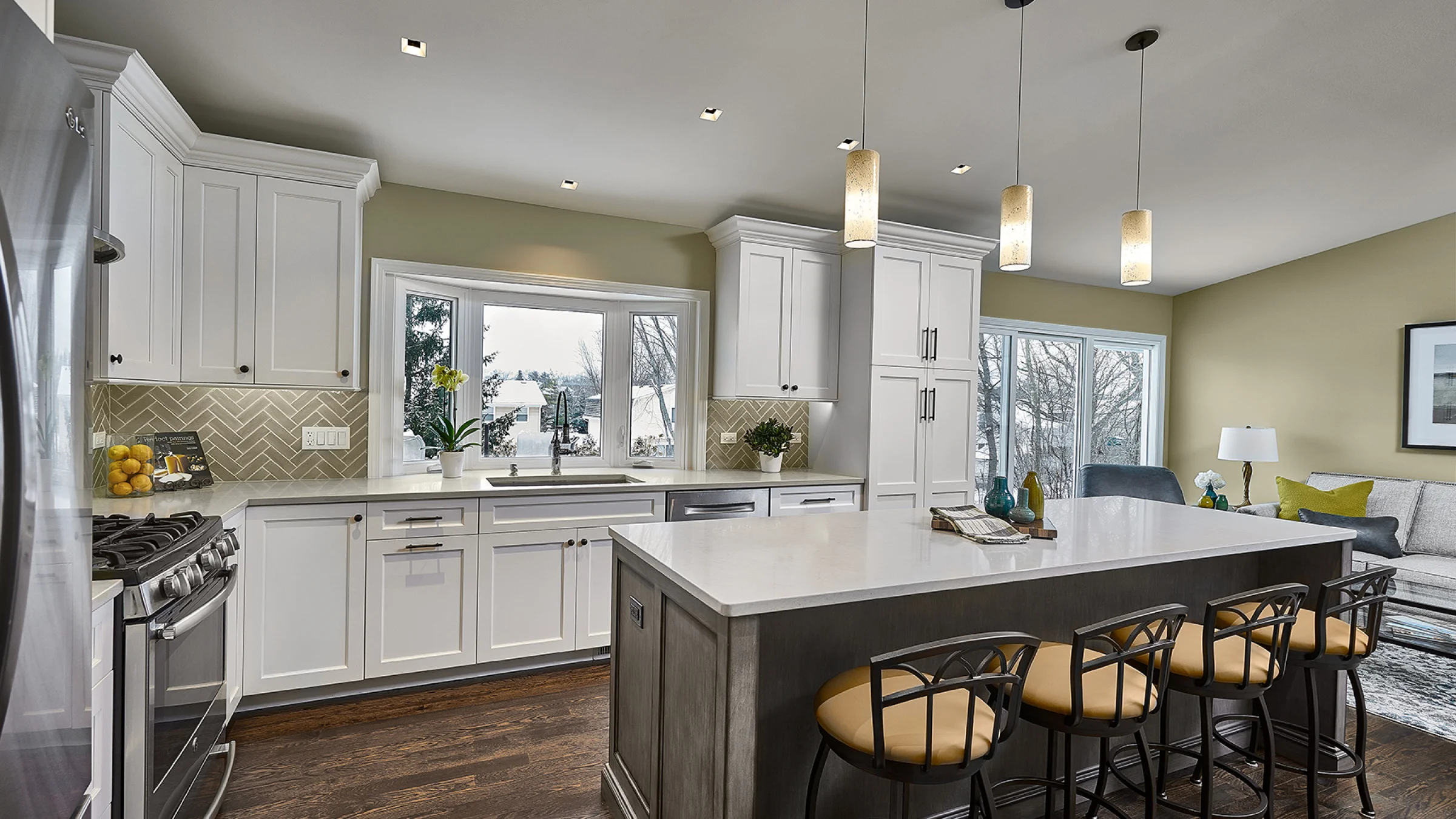 Hoffman Estates kitchen remodel with white cabinets, quartz countertops, island seating, wood floors, and modern pendant ligh