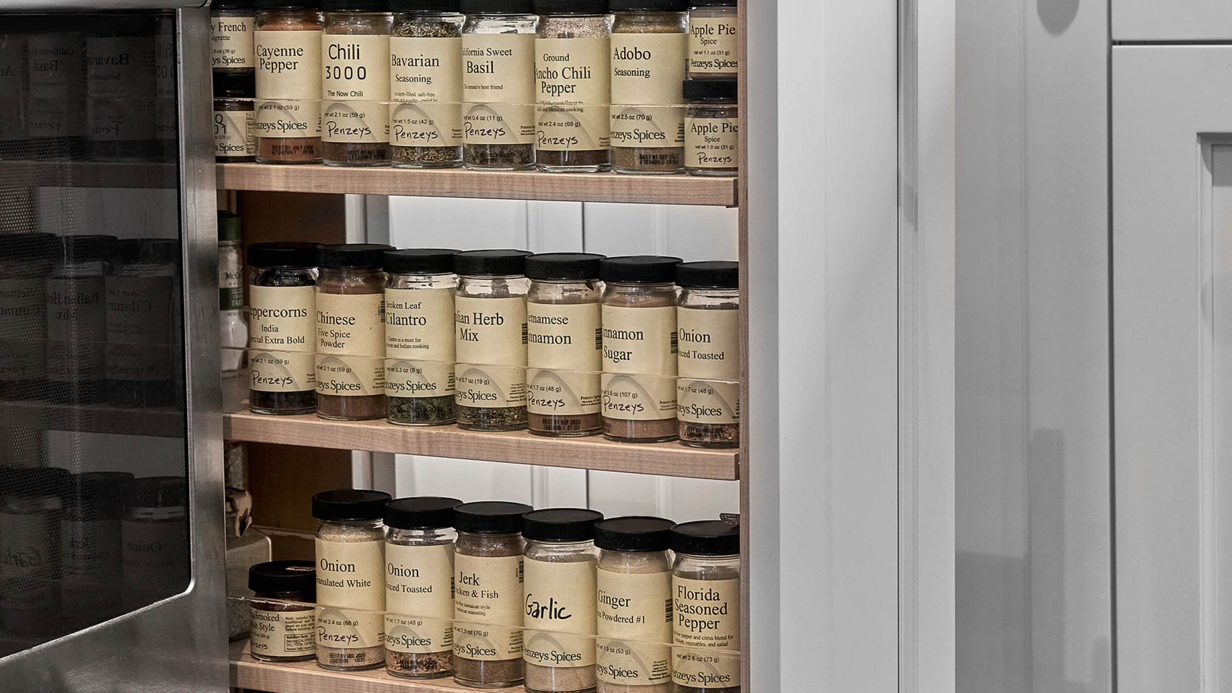 Spice rack with Penzeys spices in a remodeled Hoffman Estates kitchen. Custom storage, kitchen organization.